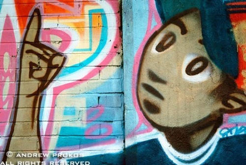 A detail from a Latin street mural in Harlem with gesturing boy, New York City