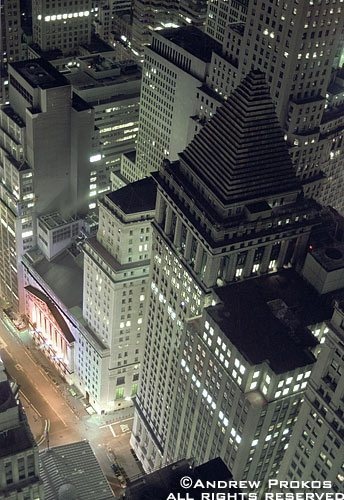 An aerial view of the skyscrapers along Wall Street and the New York Stock Exchanget at night