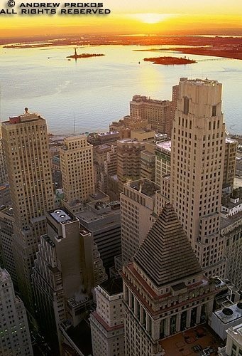 An aerial photo of Lower Manhattan, the Financial District, and New York Harbor at sunset