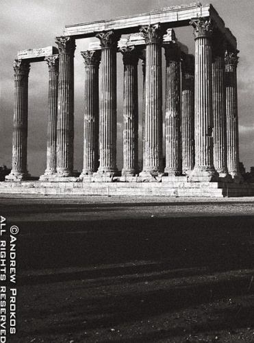 A black and white view of the ancient Temple of the Olympian Zeus in the center of modern-day Athens, Greece