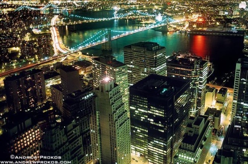 An aerial photo of Lower Manhattan, the Brooklyn Bridge, and East River at night, New York City