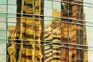 A fine art architectural photograph of the vivid reflections on a yellow glass facade in Abu Dhabi