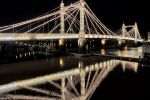 A view of the illuminated span of London's Victorian-era Albert Bridge at night reflected in the Thames River. Limited edition fine art prints are available up to 80 inches in width and framed in wood, metal, and acrylic styles. 