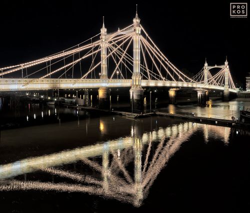 A view of the illuminated span of London's Victorian-era Albert Bridge at night reflected in the Thames River. Limited edition fine art prints are available up to 80 inches in width and framed in wood, metal, and acrylic styles. 