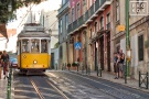 A street scene photo of a classic street trolley in the Alfama district of Lisbon, Portugal