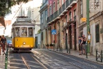A street scene photo of a classic street trolley in the Alfama district of Lisbon, Portugal