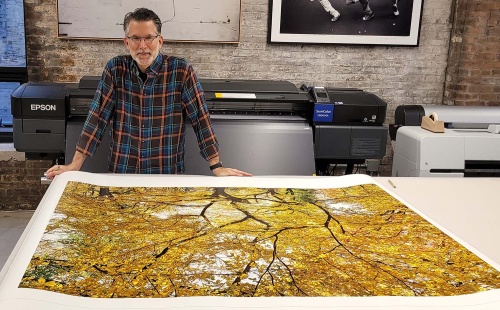 Photographer Andrew Prokos with a 60 inch large-format limited edition landscape photography print of Autumn Treescape #1