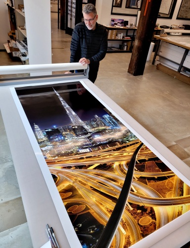 Photographer Andrew Prokos with an 80 inch panoramic print of his photo of Dubai and Burj Khalifa at Night