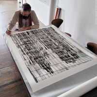 Photographer Andrew Prokos signing a 50 inch black and white limited edition print. New York City December 2021.