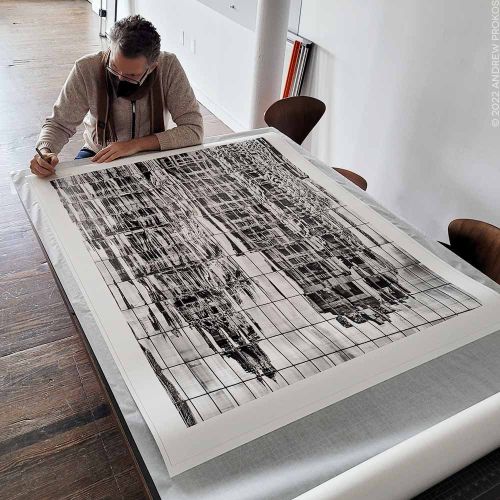 Photographer Andrew Prokos signing a 50 inch black and white limited edition print. New York City December 2021.