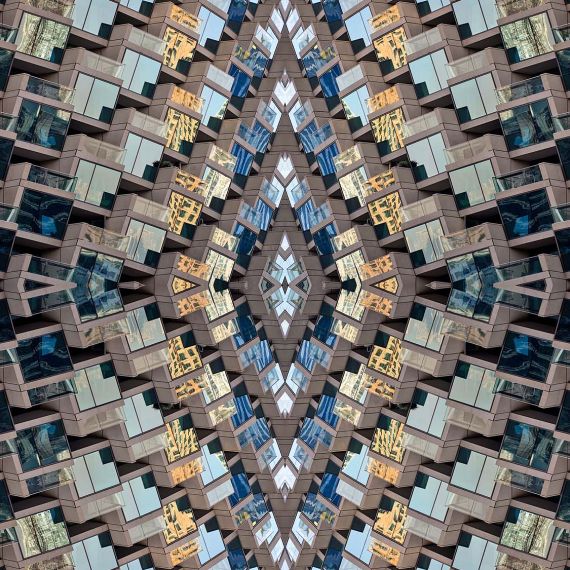 An abstract fine art photograph capturing the concentric levels of glass windows and multicolored reflections from a modern building facade in Dubai, United Arab Emirates. Large-scale limited edition prints of this photo are available up to 96 inches in width. 