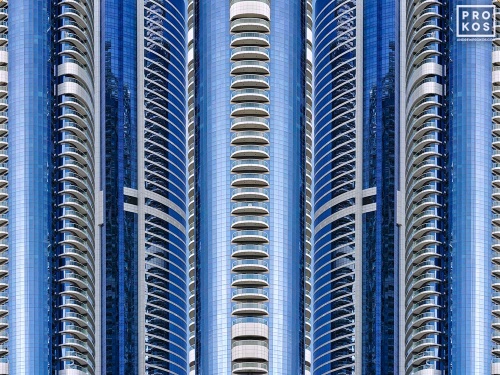 An abstract photograph composed of reflected views of contemporary blue glass tower facades in Dubai, UAE from Andrew's series Archistracts. Large-scale limited edition prints of this photo are available up to 96 inches in width.