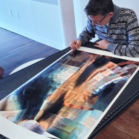 Architectural photographer Andrew Prokos signing a large-scale fine art print from his award-winning photography series 'Gehry's Children'