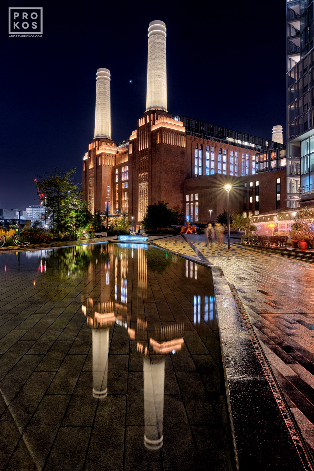 A view of Battersea Power Station reflected in a decorative pool at night, London, United Kingdom. High-definition fine art prints of this photo are available up to 72 inches in height.