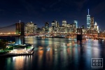 A long-exposure night view of the Brooklyn Bridge, East River, and Lower Manhattan skyline in color. Available as limited edition fine art prints framed in various styles.