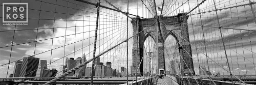 A black and white panoramic photo of the Brooklyn Bridge and its famous suspension cables, New York City