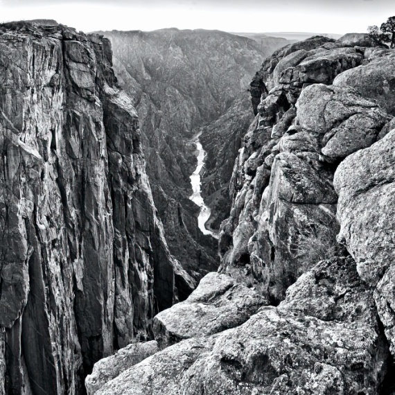 A dramatic black and white landscape from Black Canyon of the Gunnison River National Park in Colorado. Black Canyon is the steepest canyon in North America. Large format fine art prints of this photo are available framed in various styles.