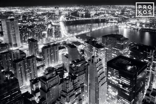 A black and white aerial view of Lower Manhattan and the Brooklyn Bridge at night, New York City