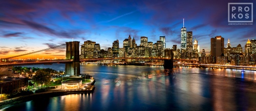 A panoramic view of the Brooklyn Bridge and the Lower Manhattan skyline at dusk, New York City