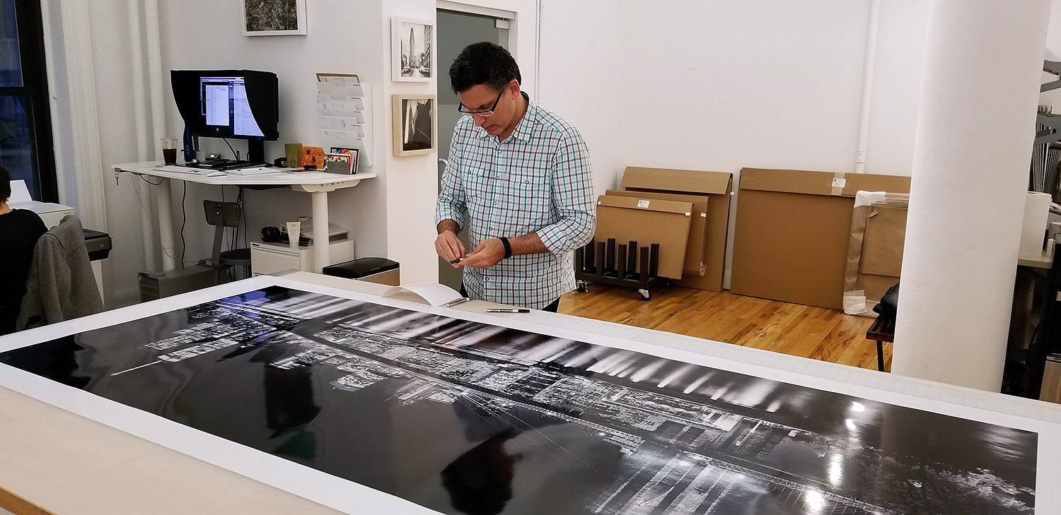 Andrew Prokos with his 90" limited edition print of "Panoramic Skyline of Brooklyn Bridge and Lower Manhattan at Night"