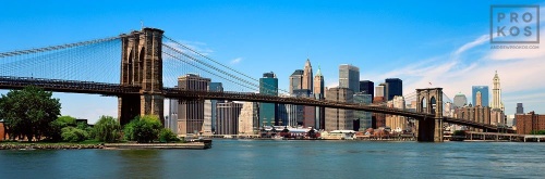 A panoramic skyline photo of the Brooklyn Bridge and Lower Manhattan during the daytime, New York City