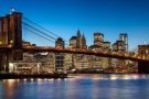A panoramic photograph of the Brooklyn Bridge and Lower Manhattan skyline at twilight