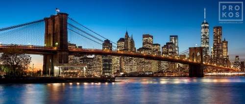 A panoramic photograph of the Brooklyn Bridge and Lower Manhattan skyline at twilight