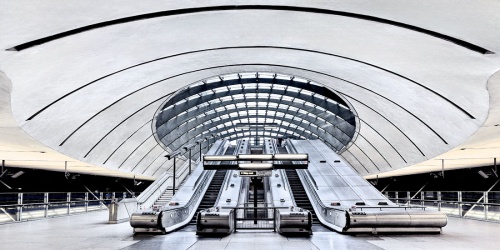 A panoramic view of the contemporary architectural interior of Canary Wharf Underground Station in London, United Kingdom. Limited-edition fine art prints of this photo are available up to 120 inches in width and framed in various wood, metal, and acrylic styles.