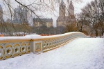 A color panoramic landscape photo of Central Park's Bow Bridge as seen under a blanket of snow in winter. Large-format fine art prints of this photo are available up to 120 inches wide and framed in various wood, metal, and acrylic styles.