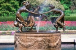 A panoramic landscape photo of the Conservatory Garden Dancing Maidens fountain in Central Park in Spring, New York City