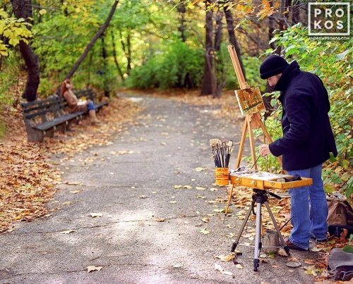 A painter with his model in Central Park in autumn, New York City. Fine art prints of this photo are available framed in various sizes.