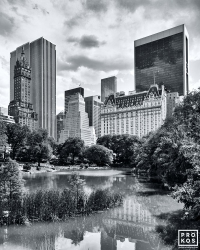 A black and white photo of the Plaza Hotel and Fifth Avenue skyline as seen from the Pond in Central Park, New York City. Limited edition fine art prints of this photo are available up to 60" in height and framed in various styles.