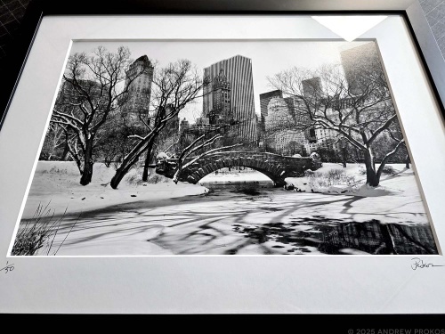 A framed black and white landscape photo of Central Park and the Gapstow Bridge under a blanket of snow by photographer Andrew Prokos