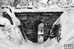 A black and white landscape photo of Central Park's Rustic Stone Arch under a blanket of Winter snow, New York City. Fine art prints of this photo are available up to 60 inches in width and framed in various wood, metal and acrylic styles.