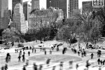 A black and white landscape photo of ice skaters in motion at Wollman Rink in Central Park, New York City. Fine art prints of this photo are available up to 60 inches in width and framed in various wood, metal, and acrylic styles. 