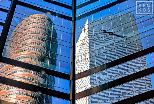 A fine art photo of Citicorp Tower and the Lipstick Building reflected on the glass facade of an East Midtown skyscraper, New York City