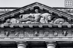A black and white architectural detail photo of the pediment from the US Department of Commerce building in black and white, Washington DC
