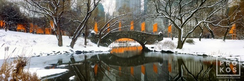 A panoramic landscape photo of Gapstow Bridge and the Lake in Central Park in winter