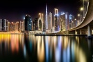 A large format photograph of the view of the Burj Khalifa and towers of Downtown Dubai at night as seen from Dubai Business Bay by photographer Andrew Prokos
