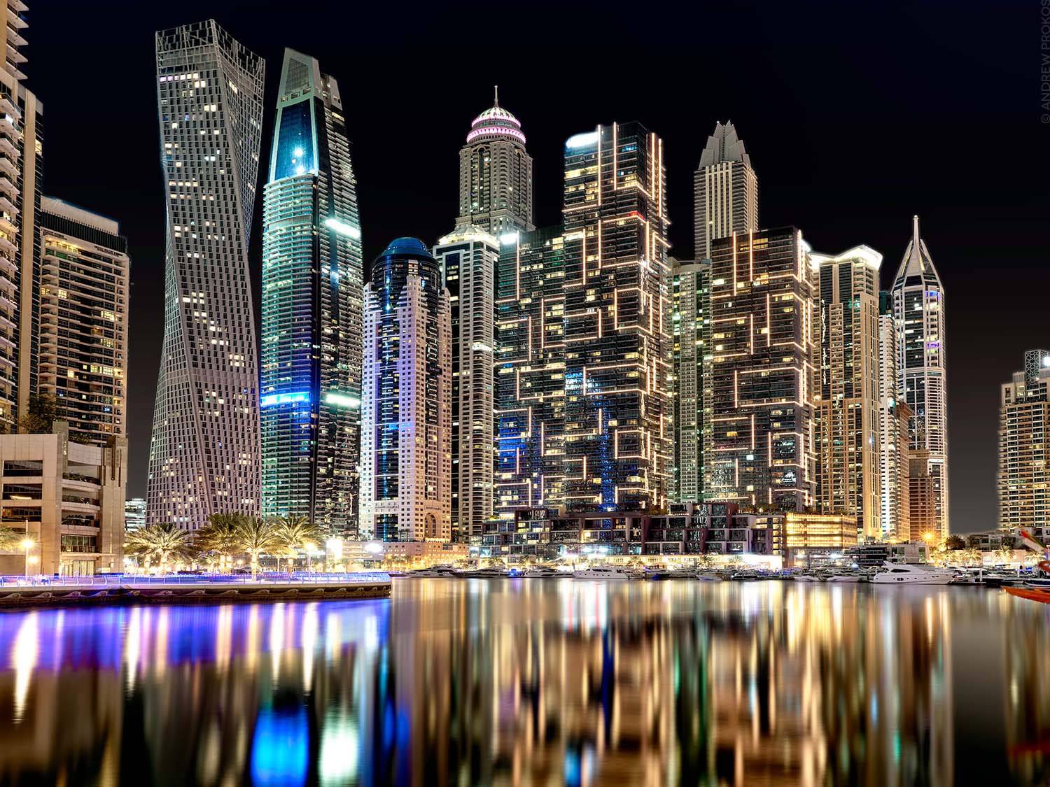 A large format photograph of the view of the tall towers of Dubai Marina at night by photographer Andrew Prokos