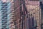 A fine art photograph of colorful reflections of modern buildings on a black glass facade in Dubai, United Arab Emirates.