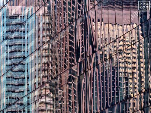 A fine art photograph of colorful reflections of modern buildings on a black glass facade in Dubai, United Arab Emirates.