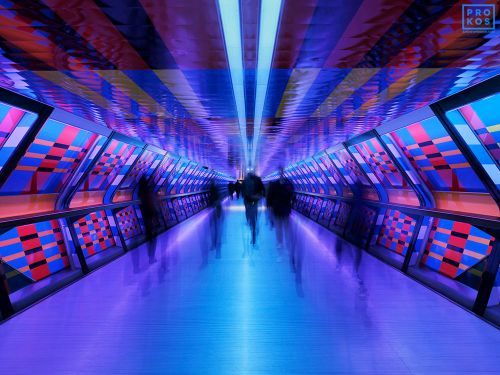 A long-exposure photograph capturing pedestrians passing through one of the colorful transit tunnels of the Elizabeth Line in London, UK. Limited edition fine art prints of this photograph are available up to 72 inches in width and framed in various styles.