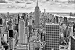 A black and white cityscape of the skyscrapers of Midtown Manhattan NYC and the Empire State Building as seen from from Rockefeller Center by photographer Andrew Prokos