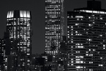 A vertical long-exposure cityscape photo of the Empire State Building at night in black and white, New York City
