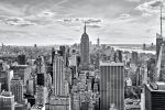 A black and white panoramic skyline of the skyscrapers of Midtown Manhattan NYC and the Empire State Building as seen from from Rockefeller Center by photographer Andrew Prokos