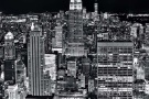 A high-definition black and white cityscape of the skyscrapers of Midtown Manhattan NYC and the Empire State Building as seen from from Rockefeller Center at night by photographer Andrew Prokos