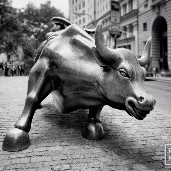 A black and white fine art photo of the famous charging bull statue in New York's Financial District