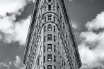 A black and white fine art architectural photo of the Flatiron Building set against the sky, New York City