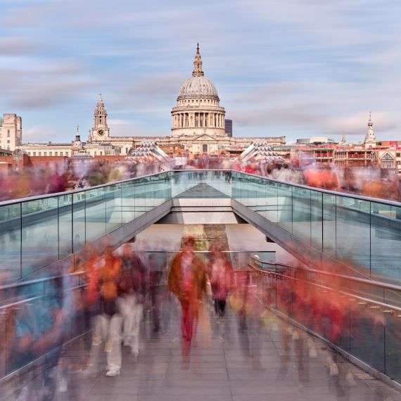 A conceptual photograph capturing the flow of pedestrians in motion crossing London's Millennium Bridge. The composition incorporates numerous high-definition images, each one captured using long exposure times. The individual images are then seamlessly merged into a single large-scale composition. Limited edition prints of this photo are available up to 80 inches in width.